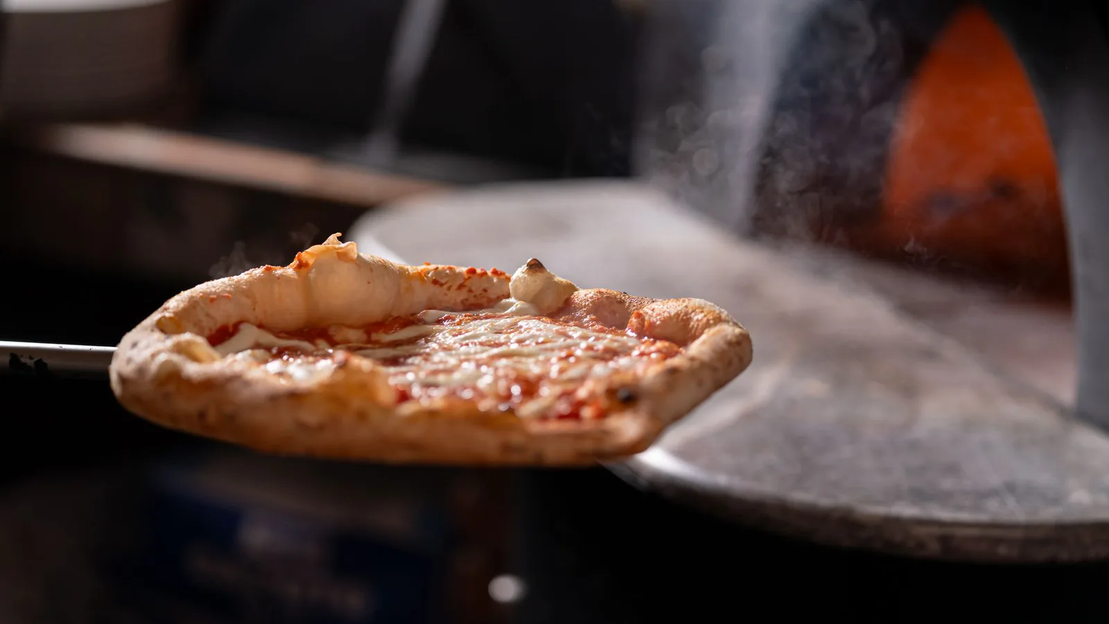 Steaming hot pizza fresh from the oven with melted cheese and crispy crust