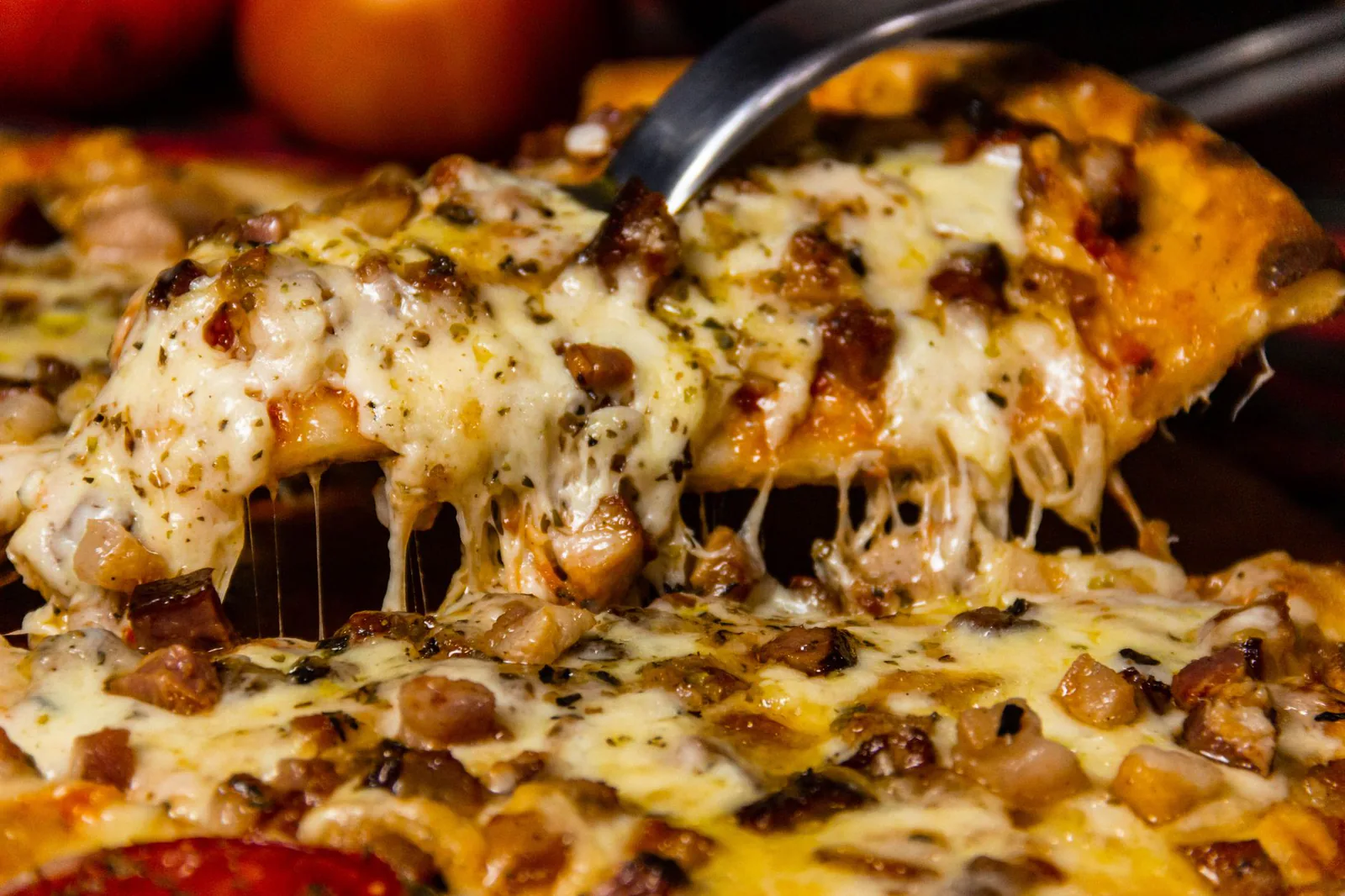 Motor City Meat Feast pizza, cheesy slice being served