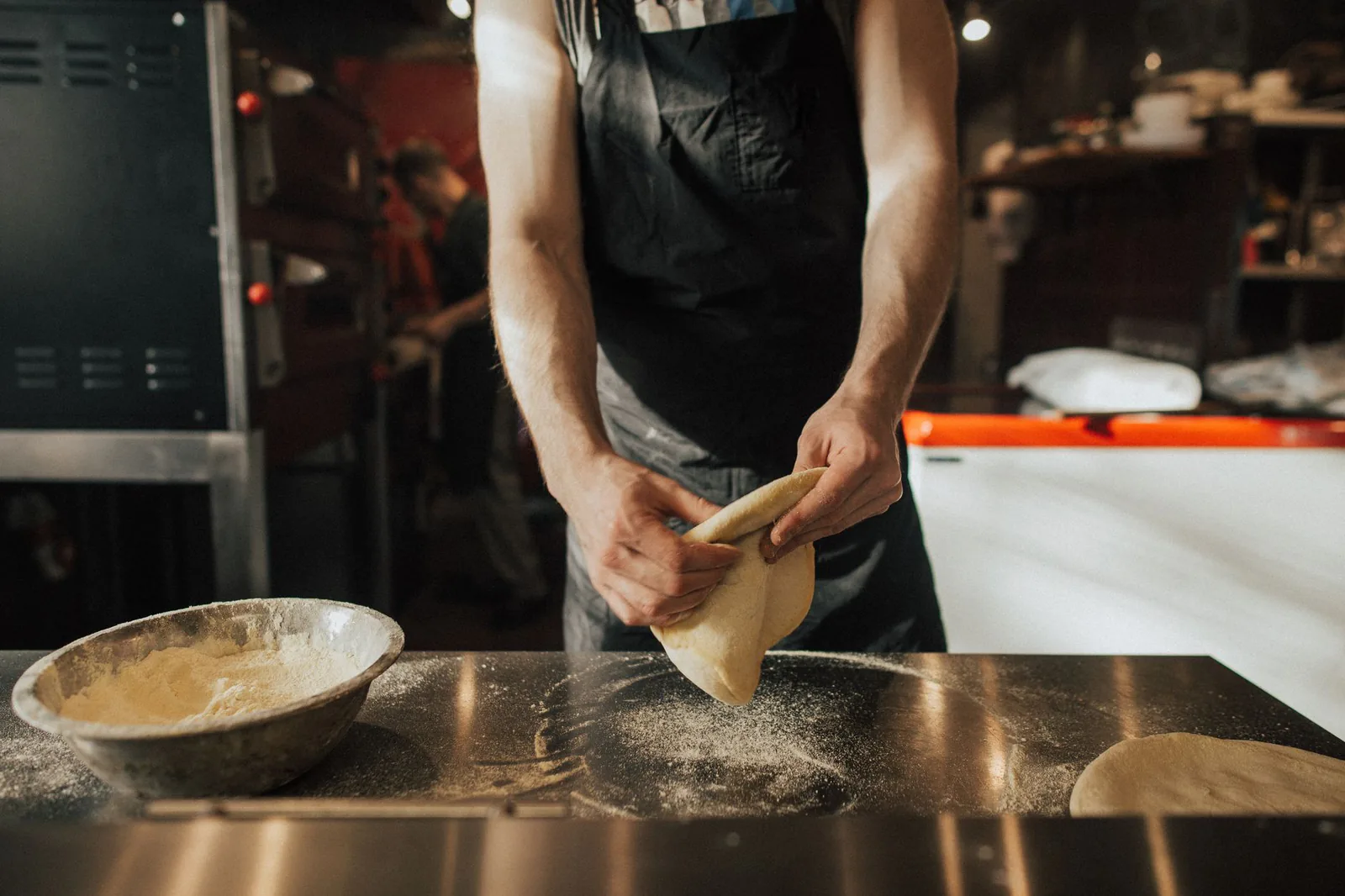 Chef preparing pizza dough in the kitchen