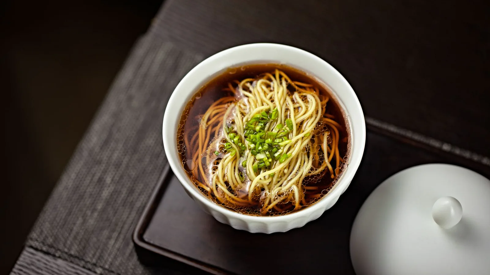 Noodle bowl in savory broth with green onions