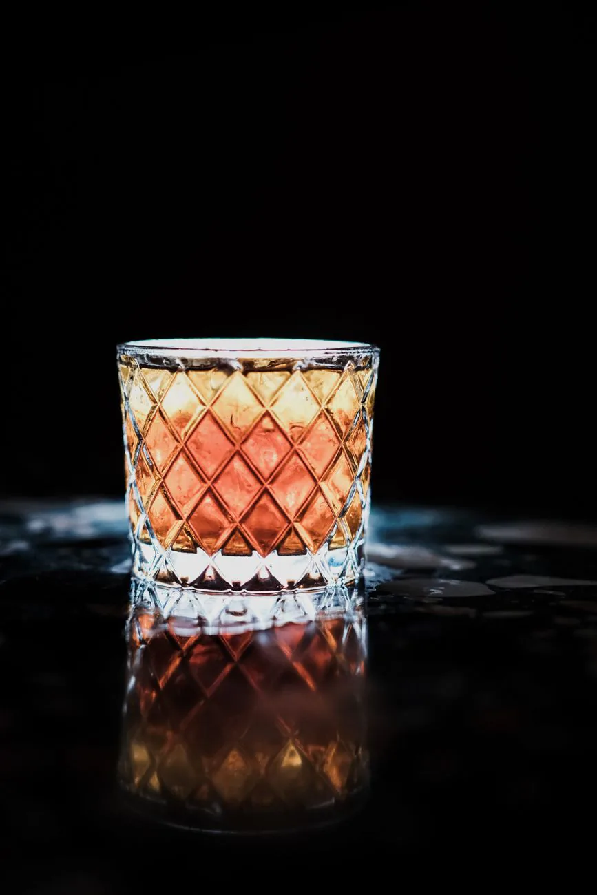 Whiskey glass on a dark bar counter