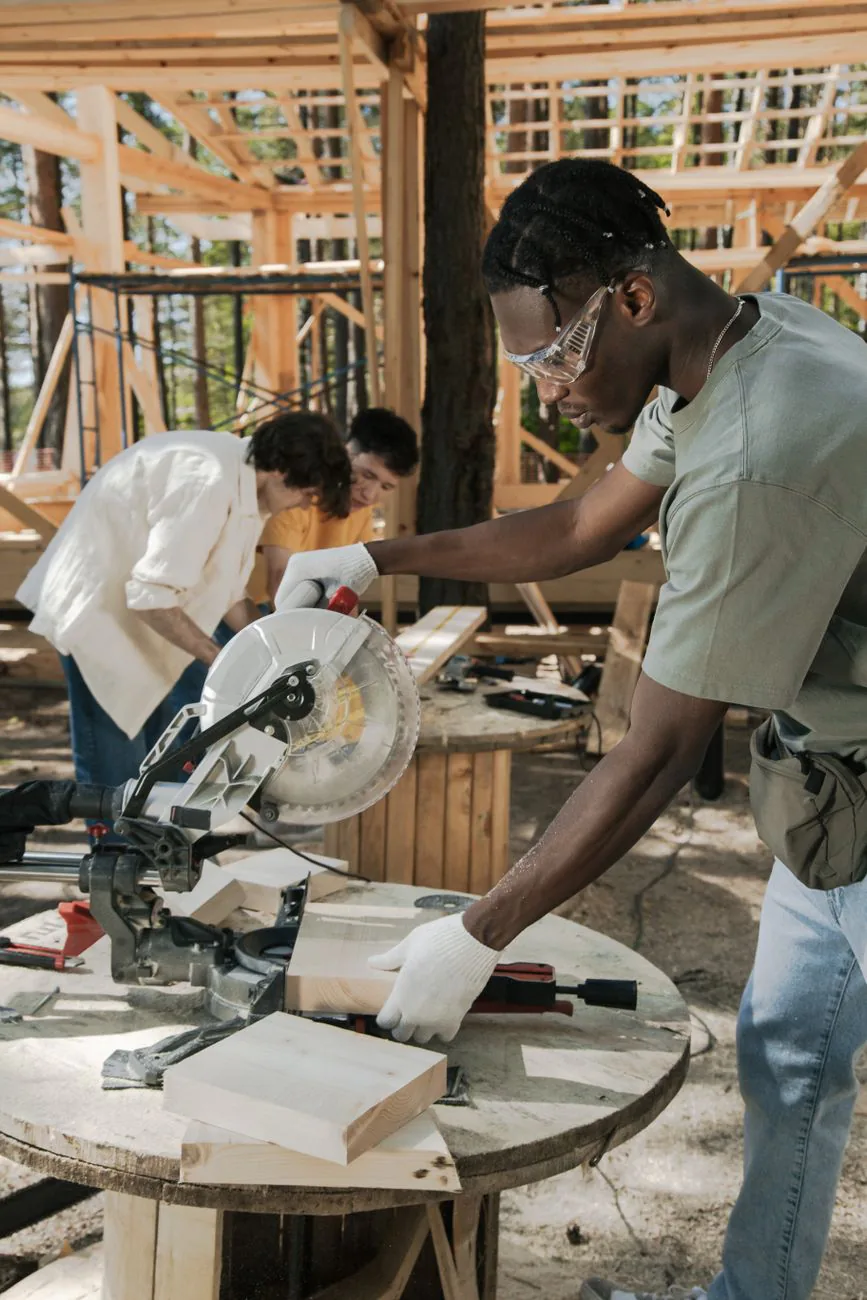 Dione carpenter cutting lumber with precision on site