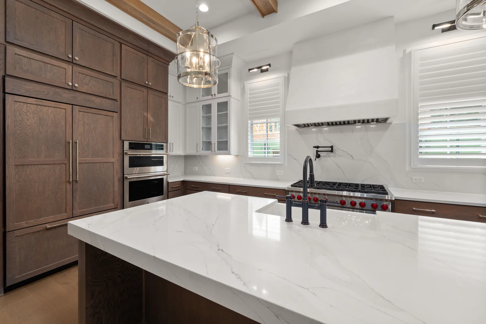 Warm modern kitchen with marble island and wood cabinetry