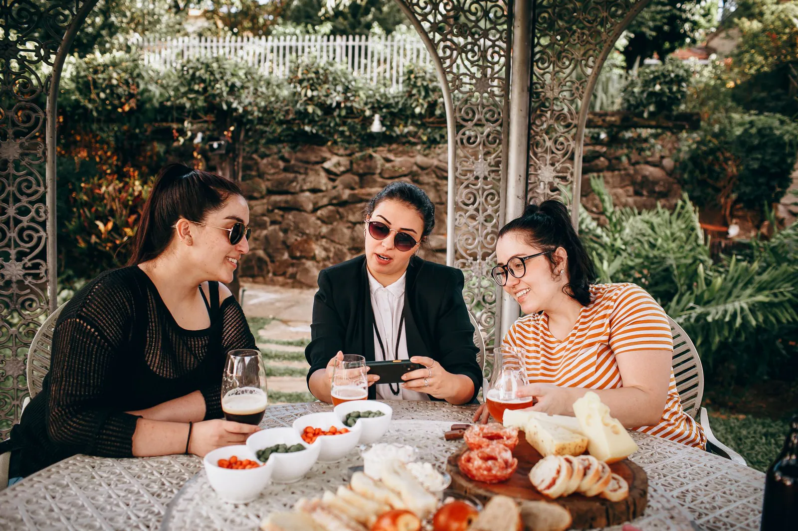 A table full of guests eating and laughing outdoors