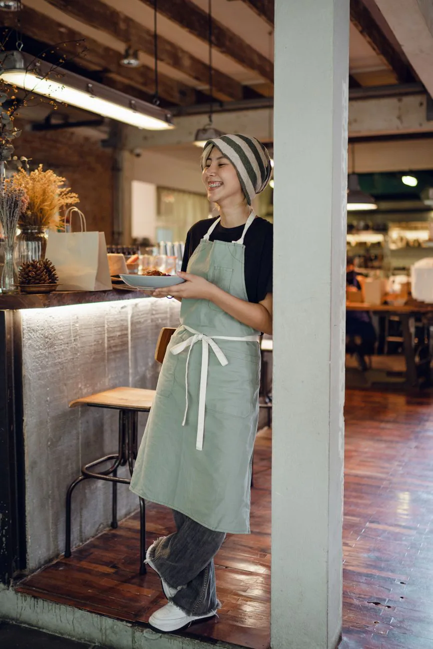 A smiling Ellen's server bringing plates to the table
