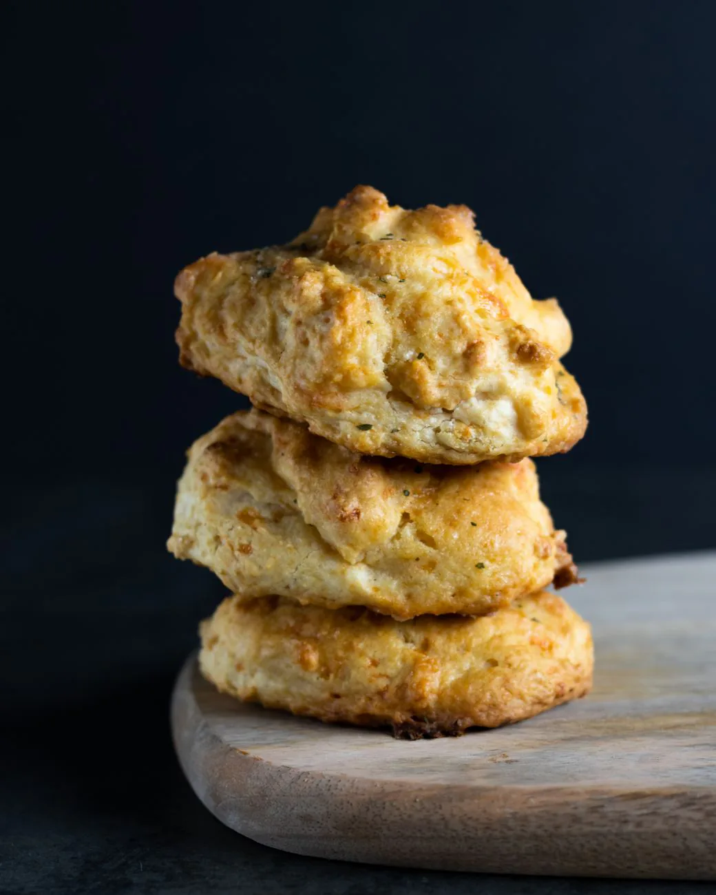 Fresh biscuits stacked on a wooden board