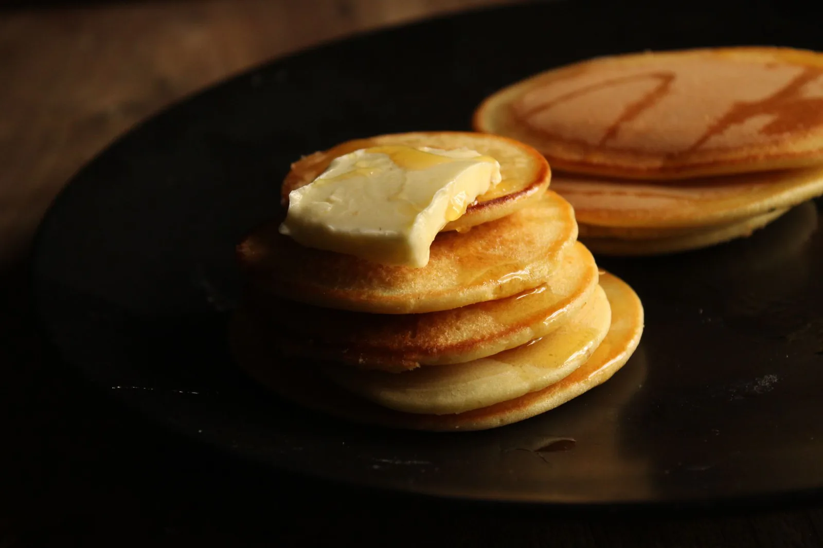 Stack of buttermilk pancakes with melting butter and syrup