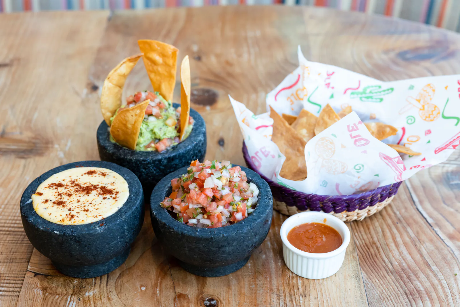 Guacamole, salsa and queso in molcajetes with tortilla chips