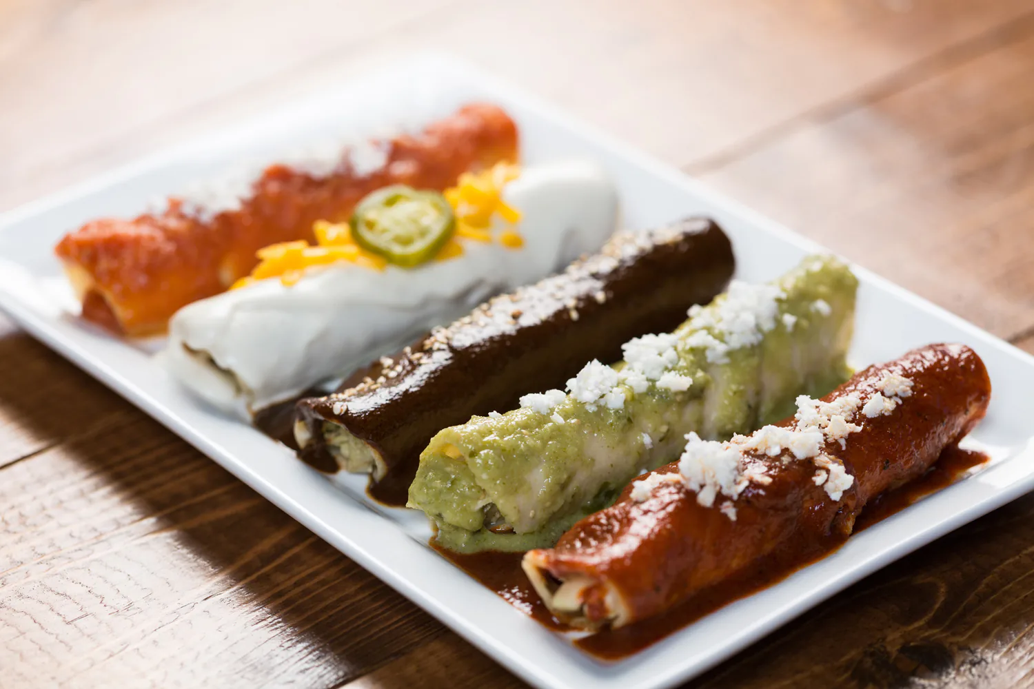 A plate of El Vecino enchiladas with rice and beans