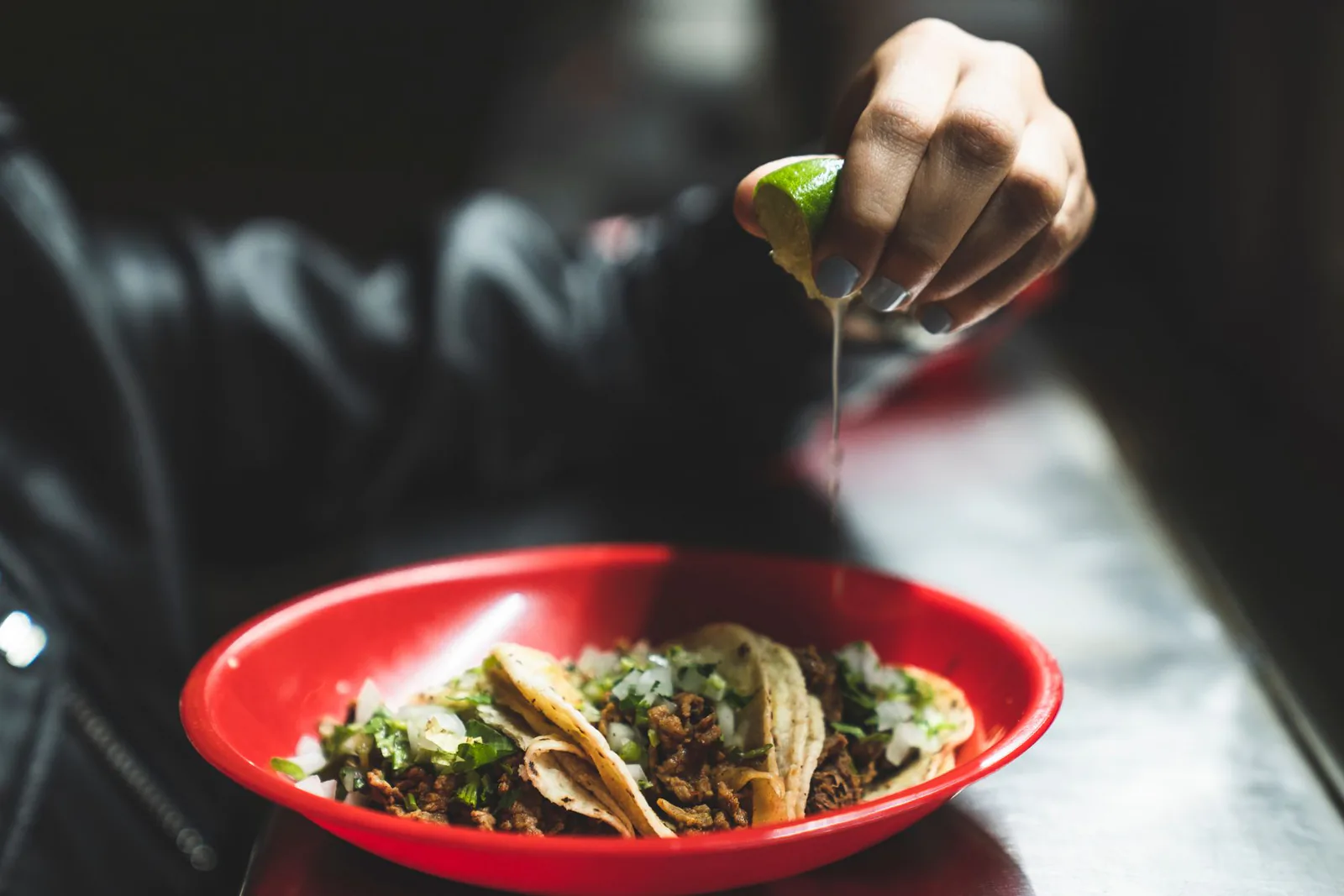 Street tacos with lime squeezed over the top at El Vecino