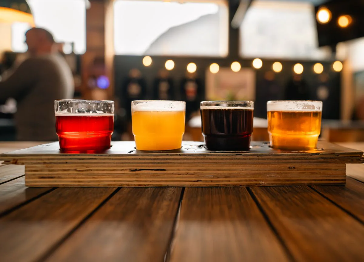 A row of craft beers on a rustic tavern table