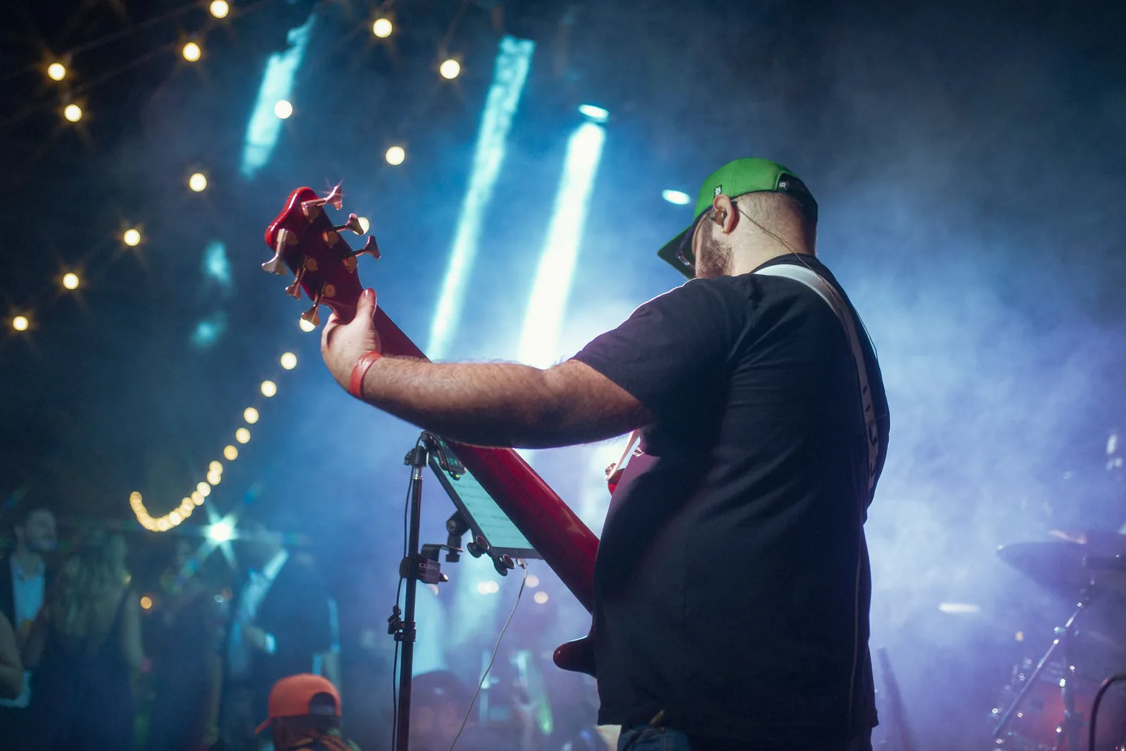 Guitarist performing under warm string lights