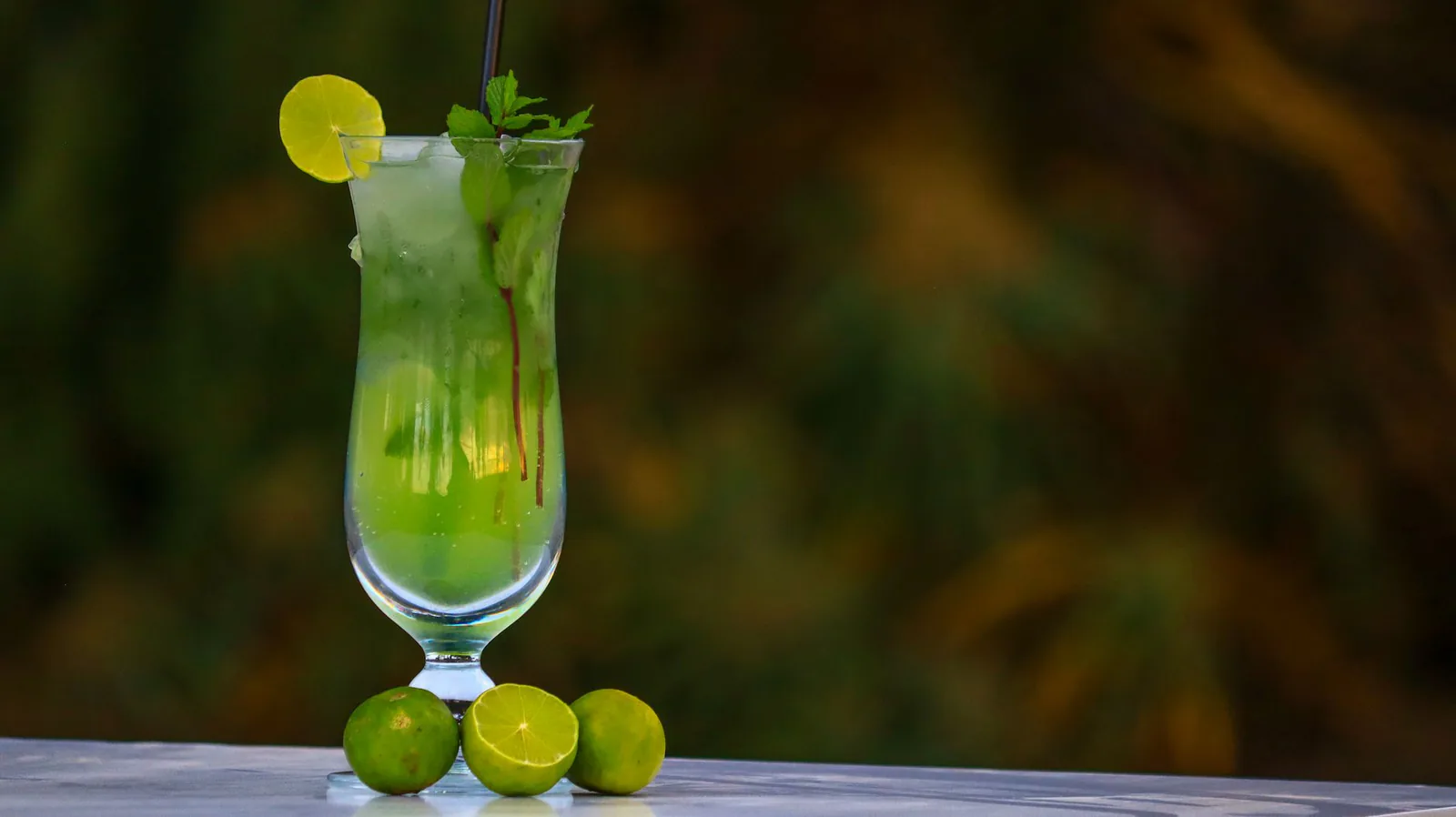Tall mojitos with lime and mint on the table
