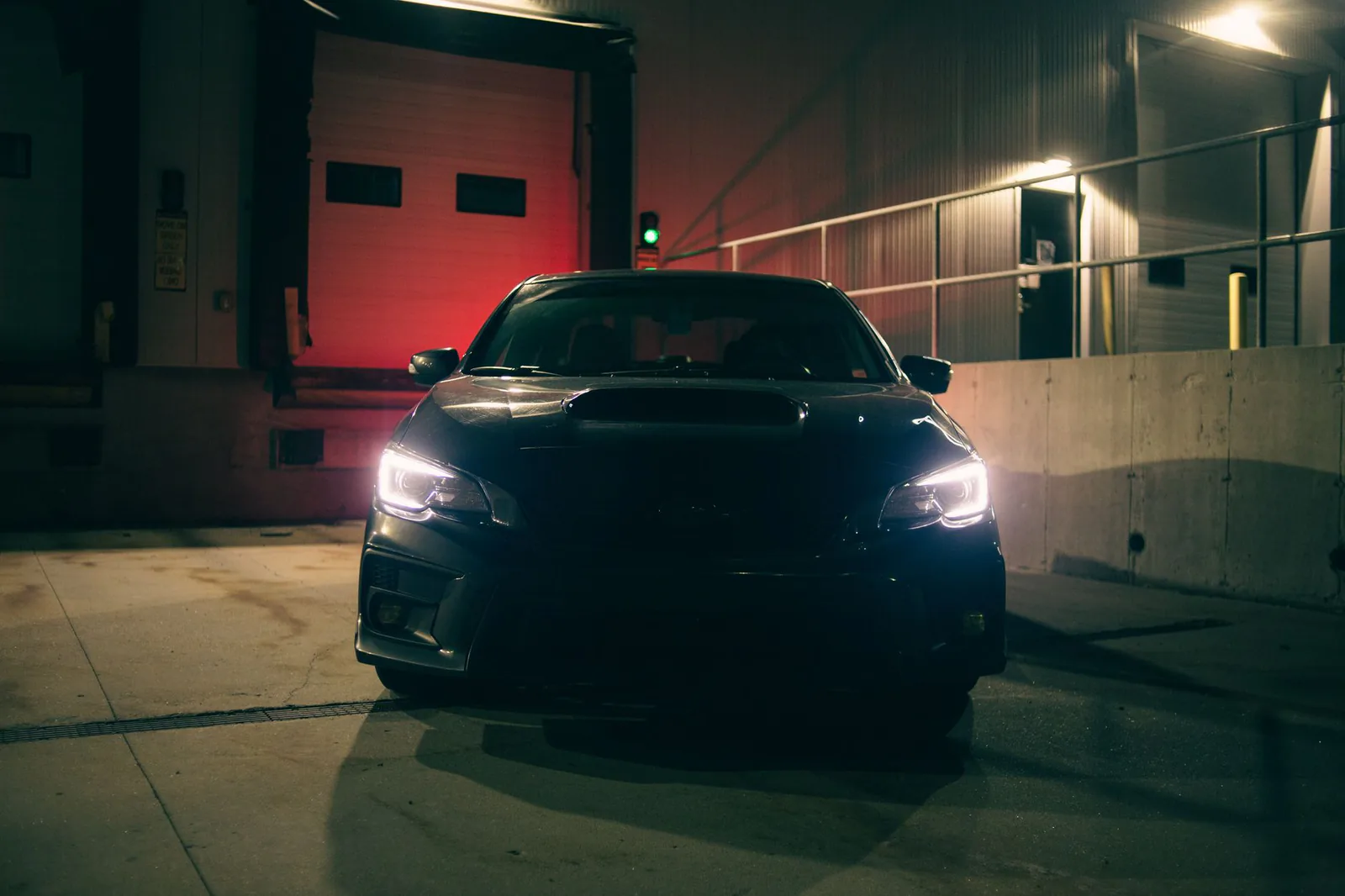 Black sports car with headlights on at night