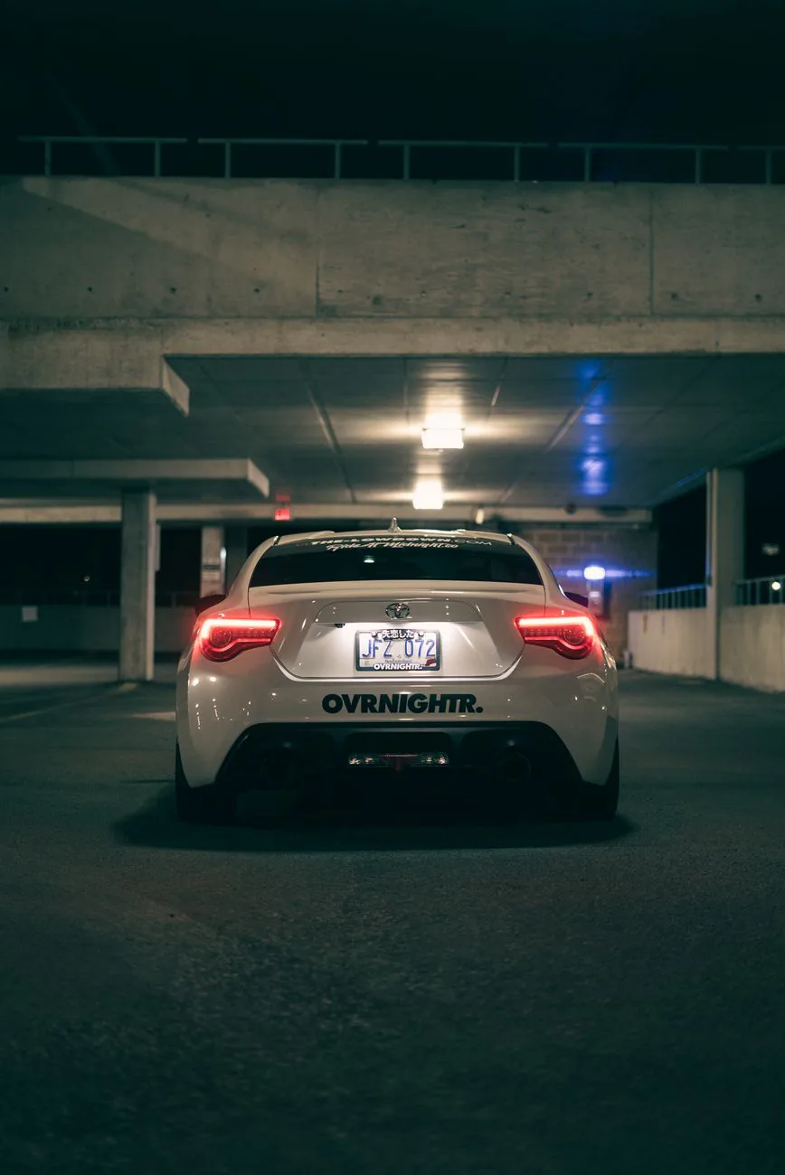 Sports car with illuminated taillights in a parking garage