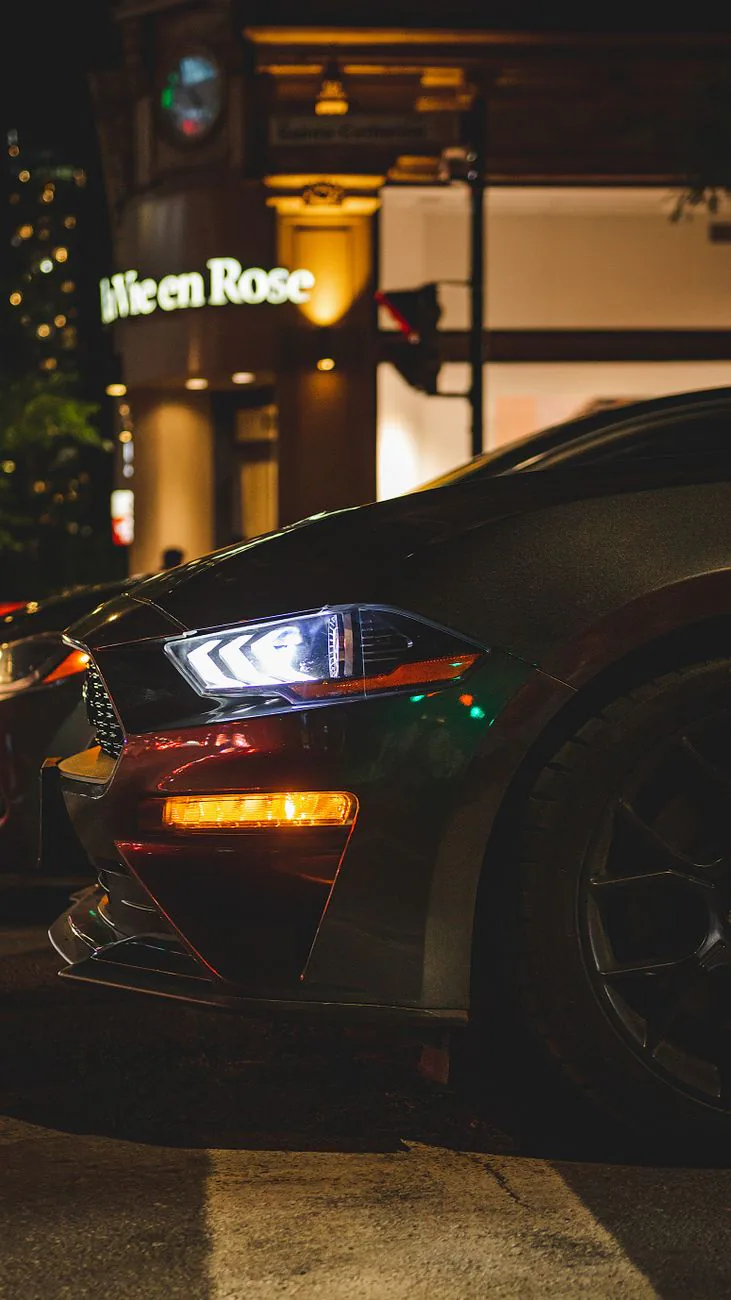Black sports car side profile under city lights at night