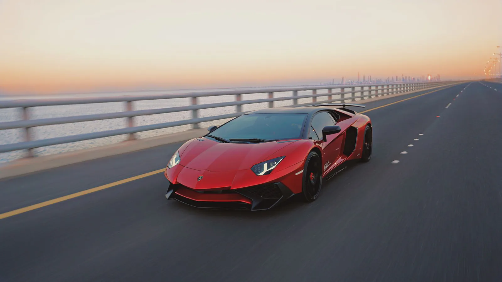 Car driving an open coastal road at sunset