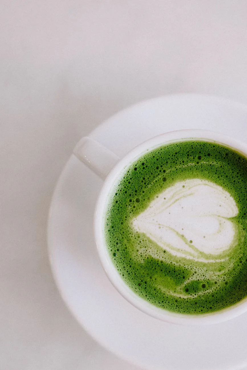 Matcha latte in a porcelain cup with heart-shaped foam art on a neutral background