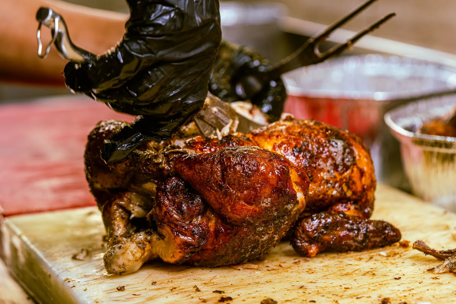 Juicy rotisserie chicken being carved on a wooden board