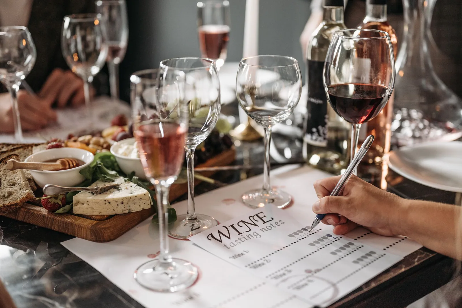 A wine and cheese pairing laid out on a wooden table