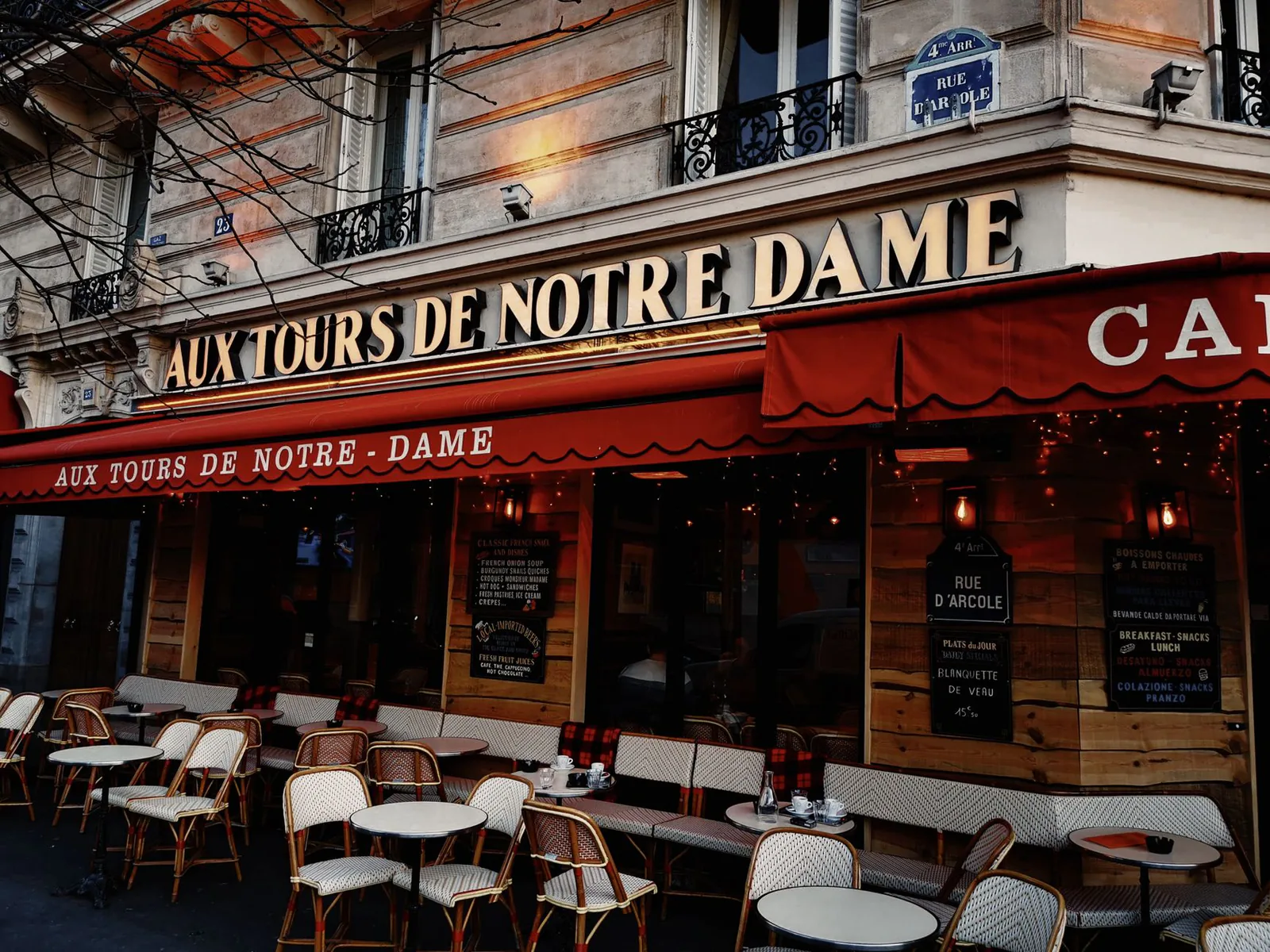 Warmly lit Parisian cafe exterior in the evening