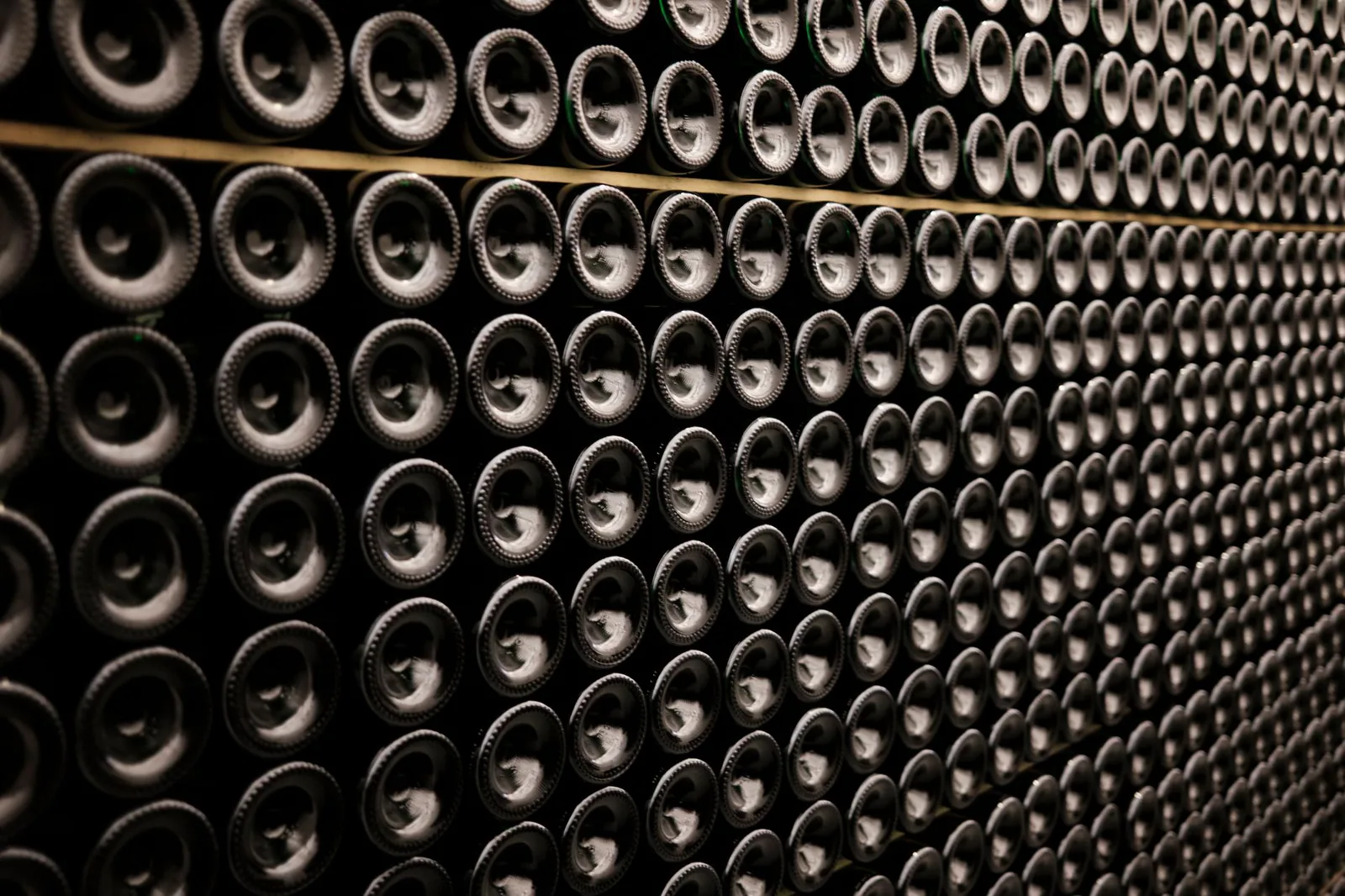 Wine bottles stacked symmetrically on a cellar rack