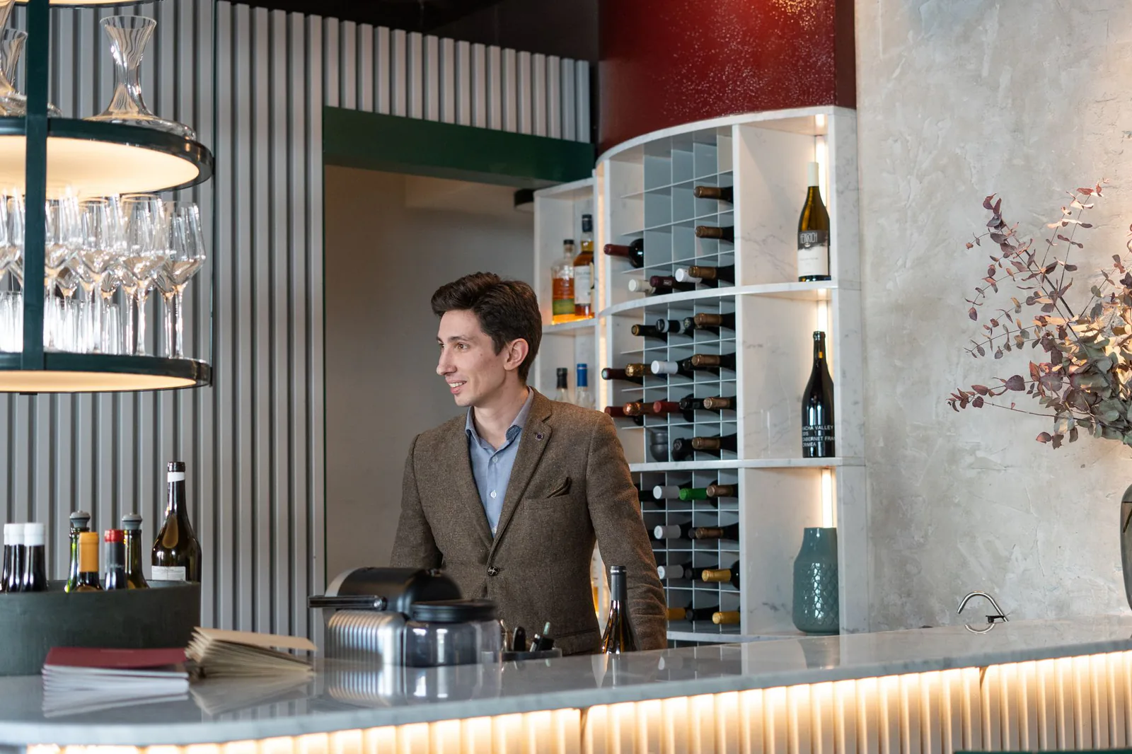Bartender attending an elegant wine bar with a well-organized collection