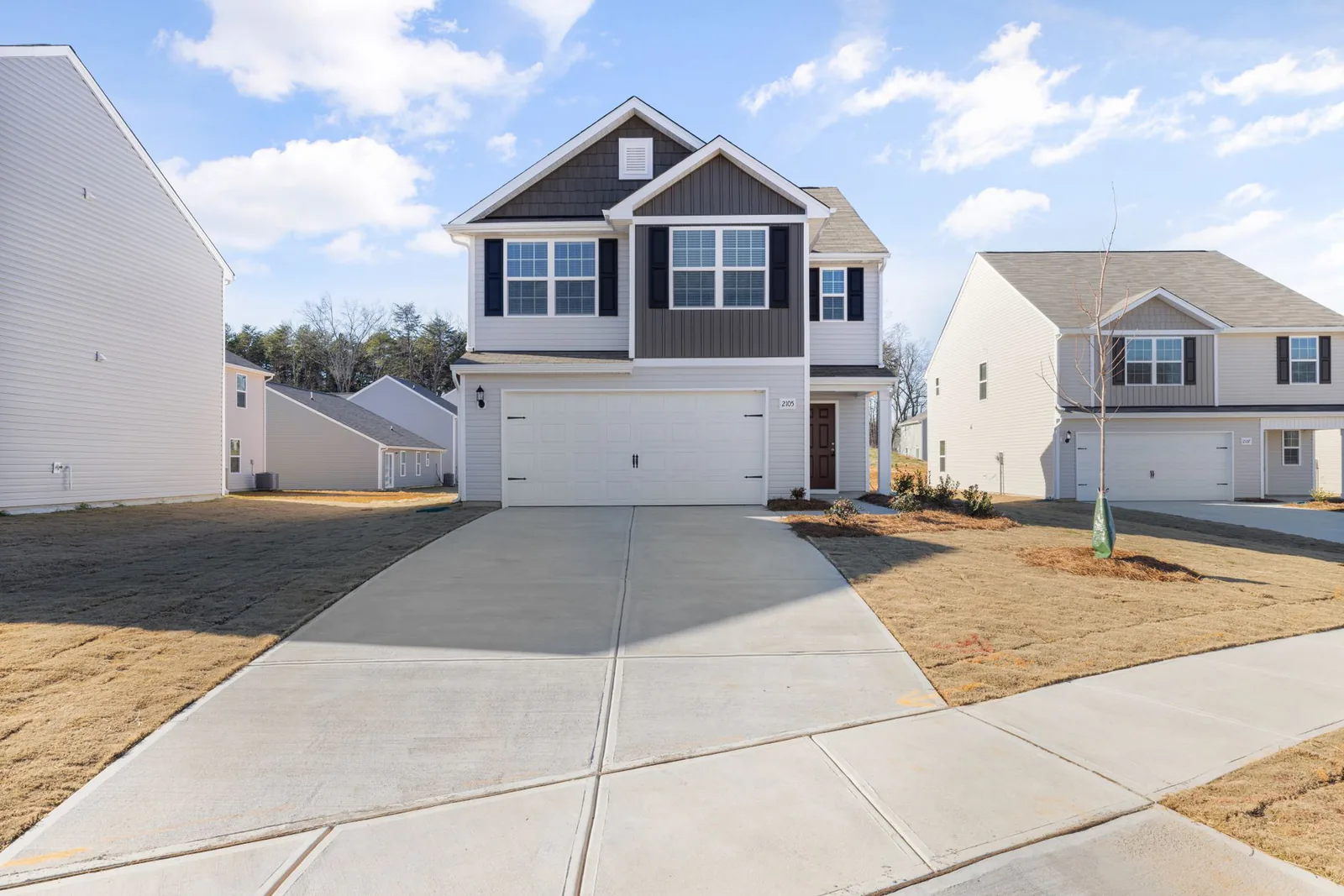 Wide finished concrete driveway in a suburban neighborhood