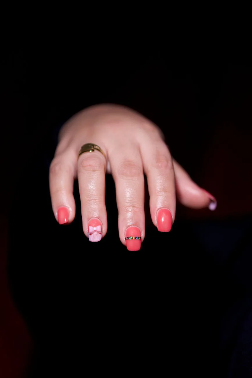 Intricate pink nail art with gold detail
