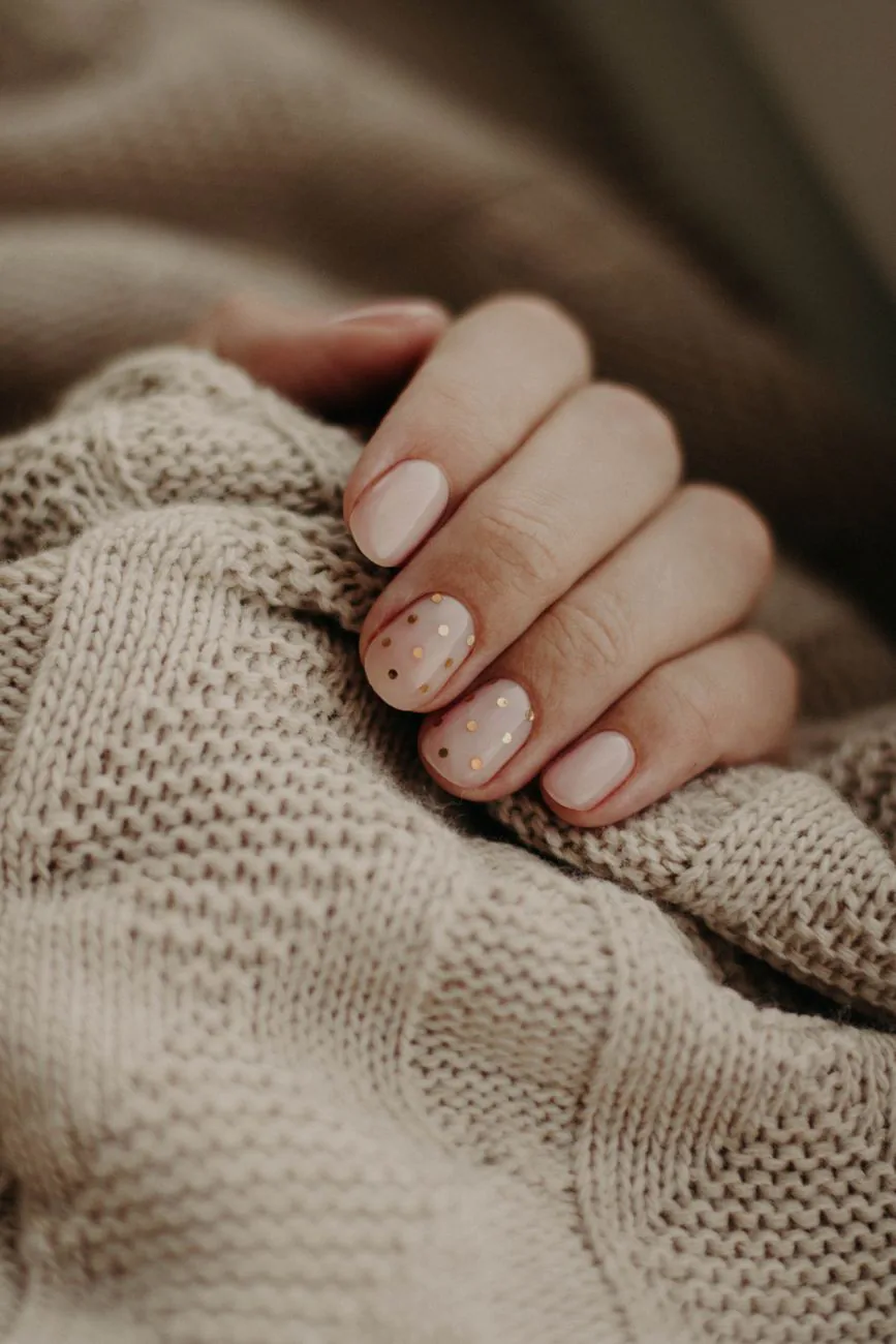 Polka dot manicure wrapped in a knit sweater