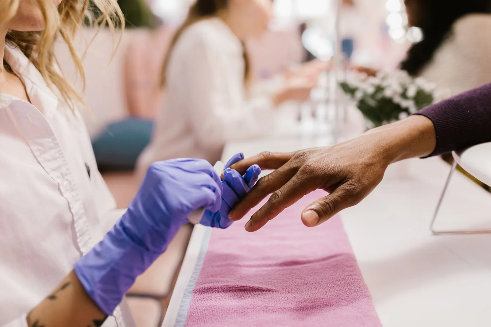 Manicurist applying polish during a manicure
