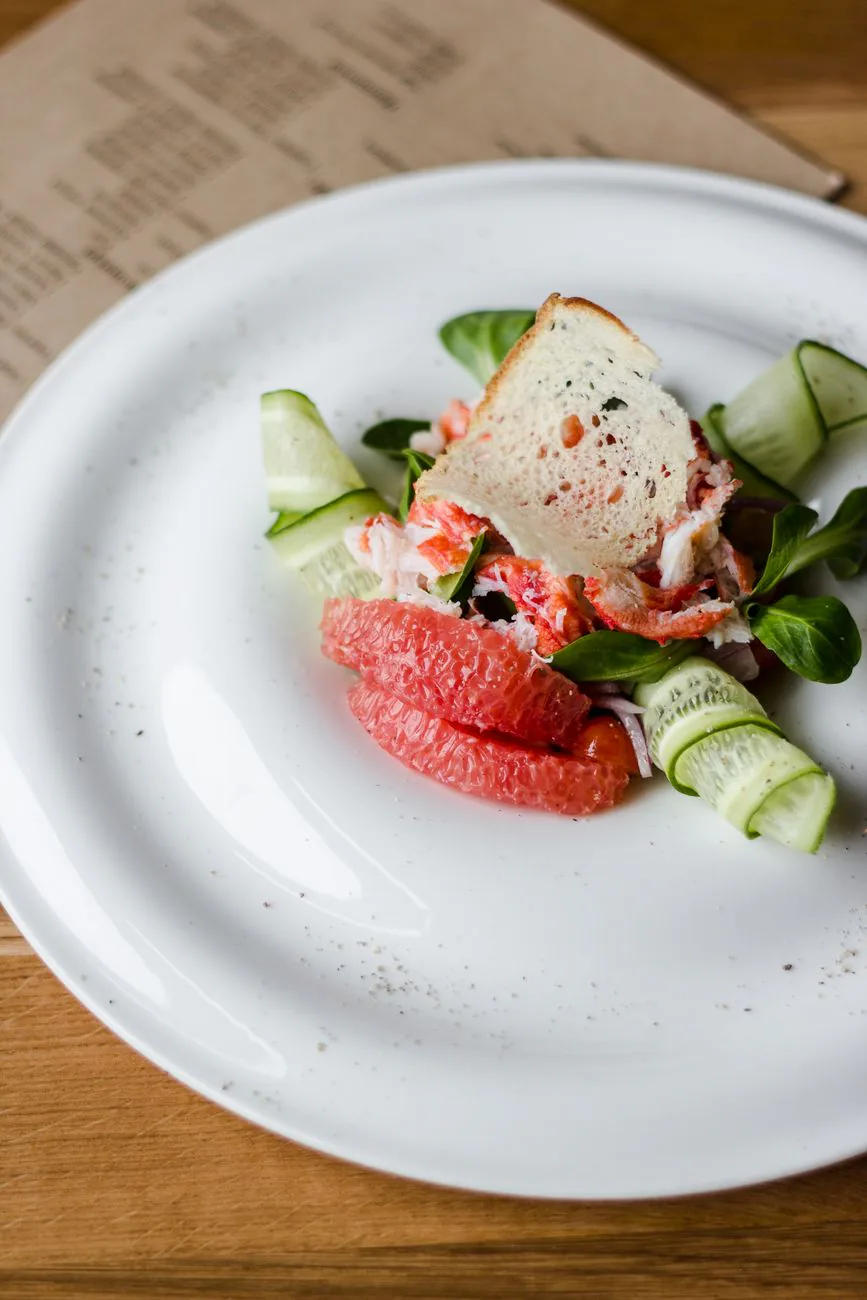 Cucumber, feta, and mint salad in a white bowl with lemon