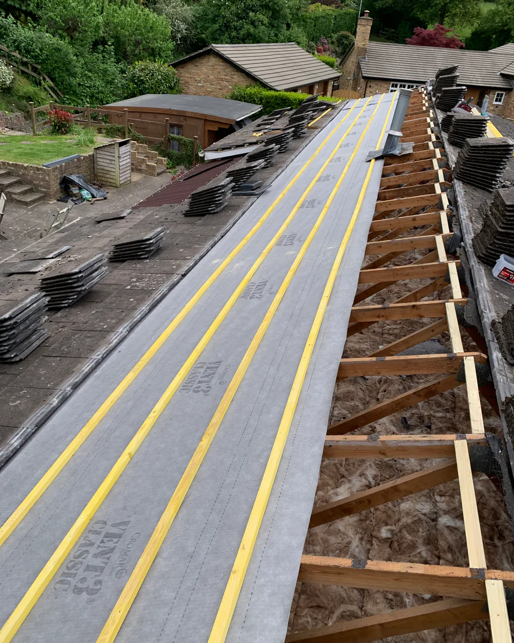 Roofer repairing damaged roof tiles and leadwork