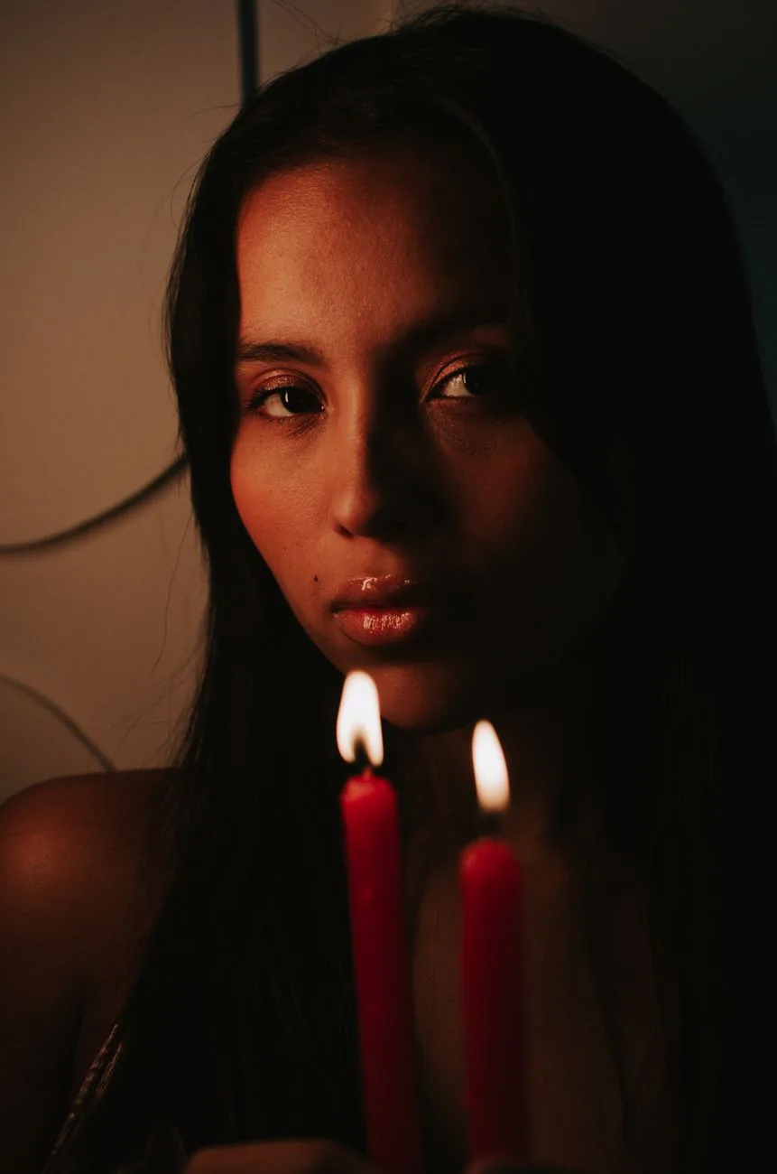 A woman lit softly by candlelight