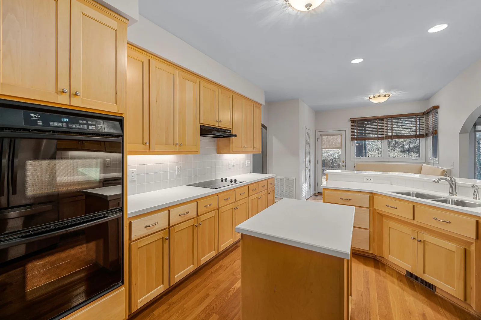 Renovated kitchen with wood cabinetry and island built by Scorpion Renovation Group