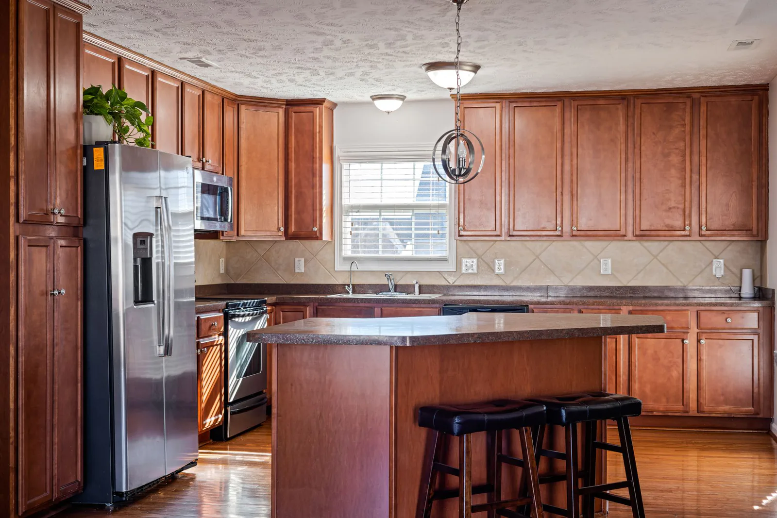 Kitchen before renovation — dated wood cabinets