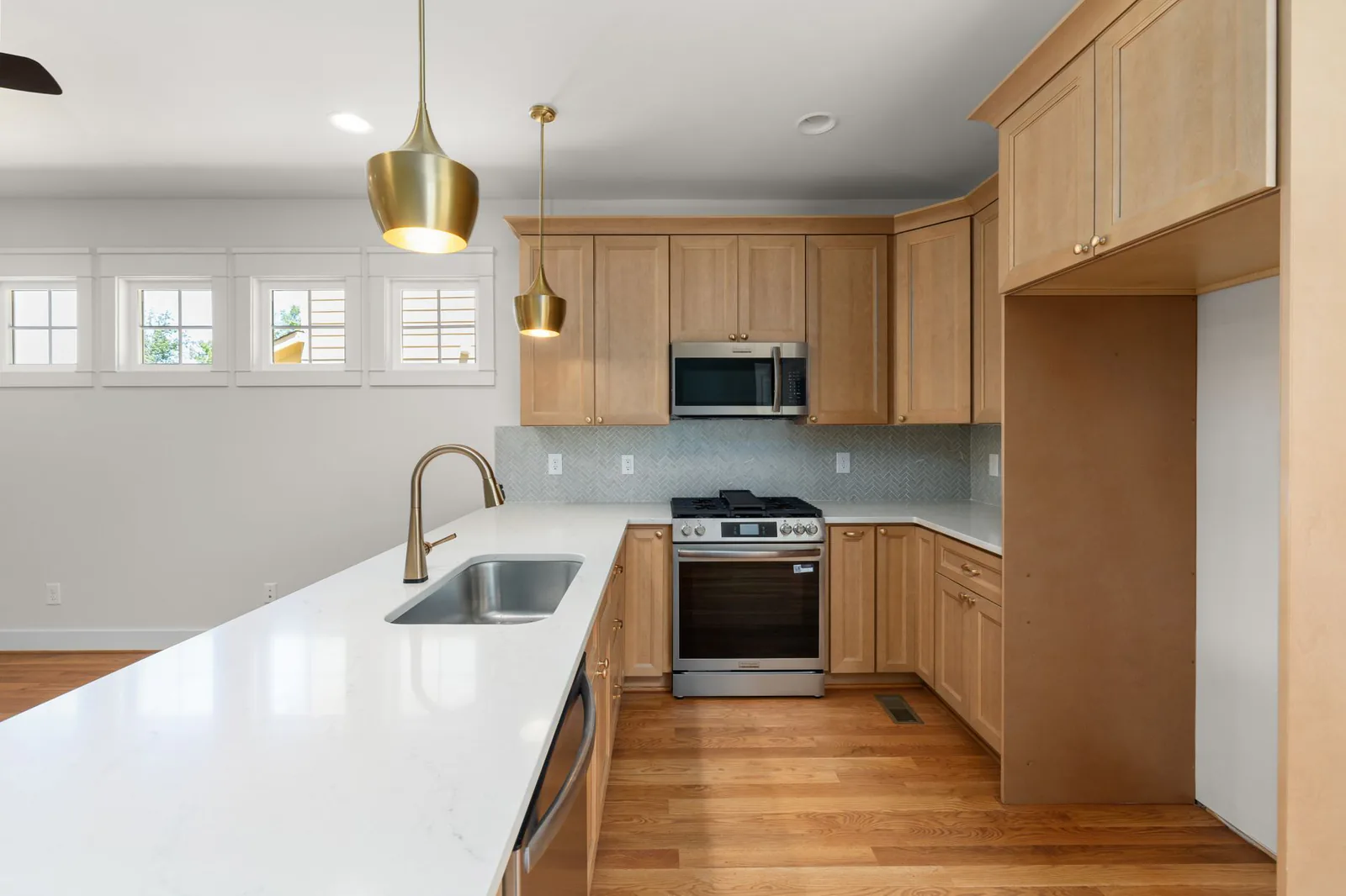 Modern kitchen renovation with wood cabinets and pendant lighting