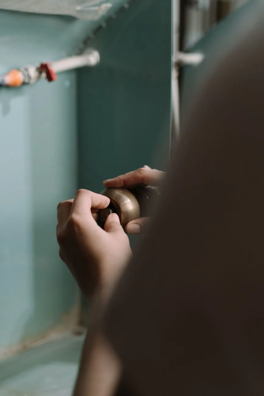 Close-up of a plumber repairing the supply lines under a kitchen sink