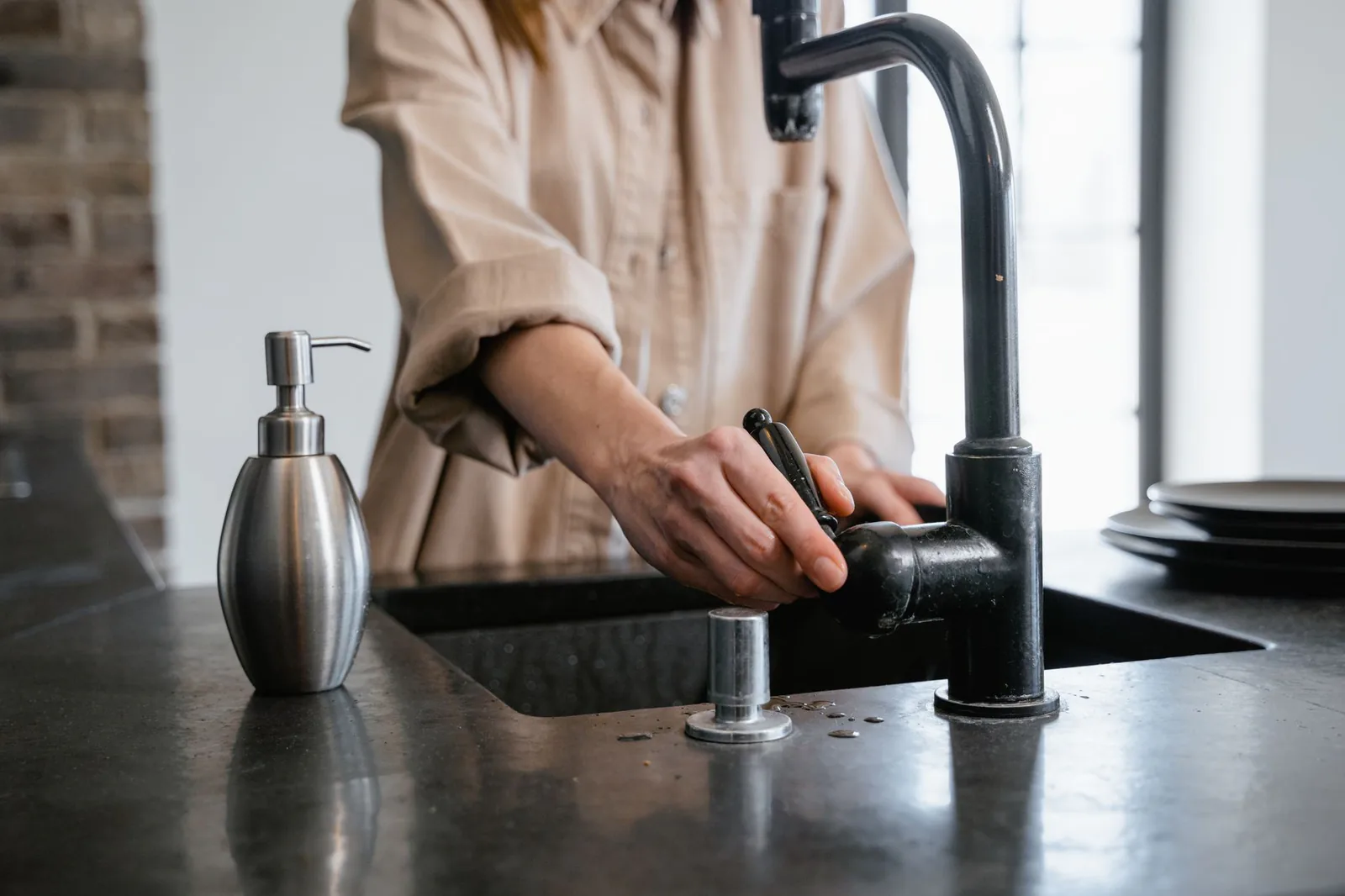 Kitchen sink with water running during a drain cleaning visit