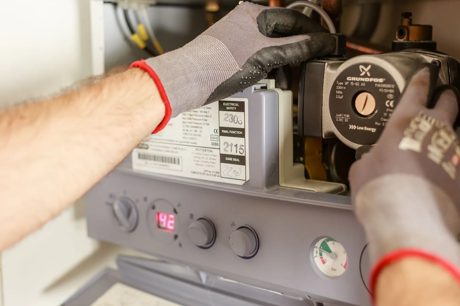 Technician servicing a residential water heater and its connections