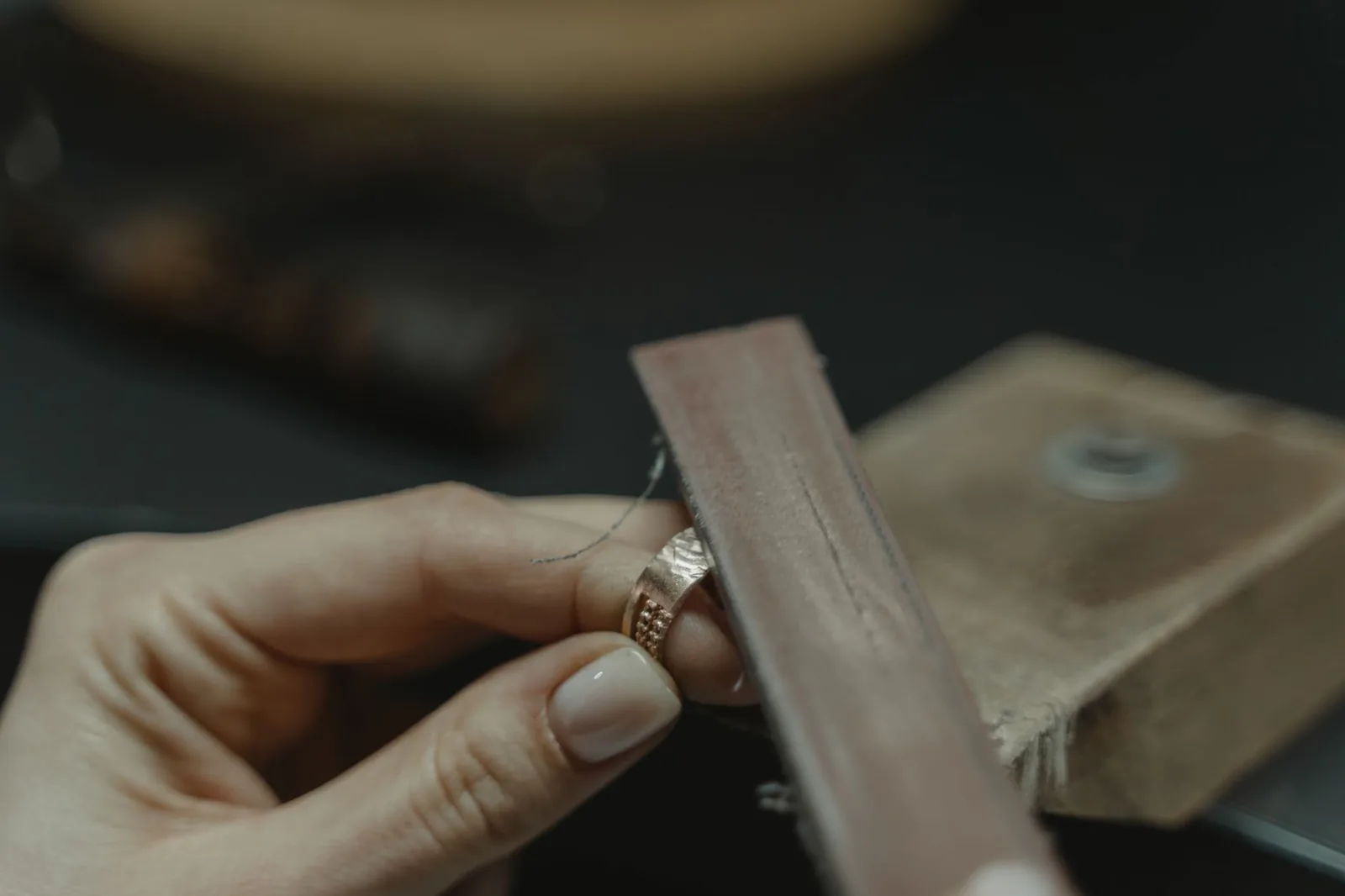 Close-up of hands polishing a gold ring