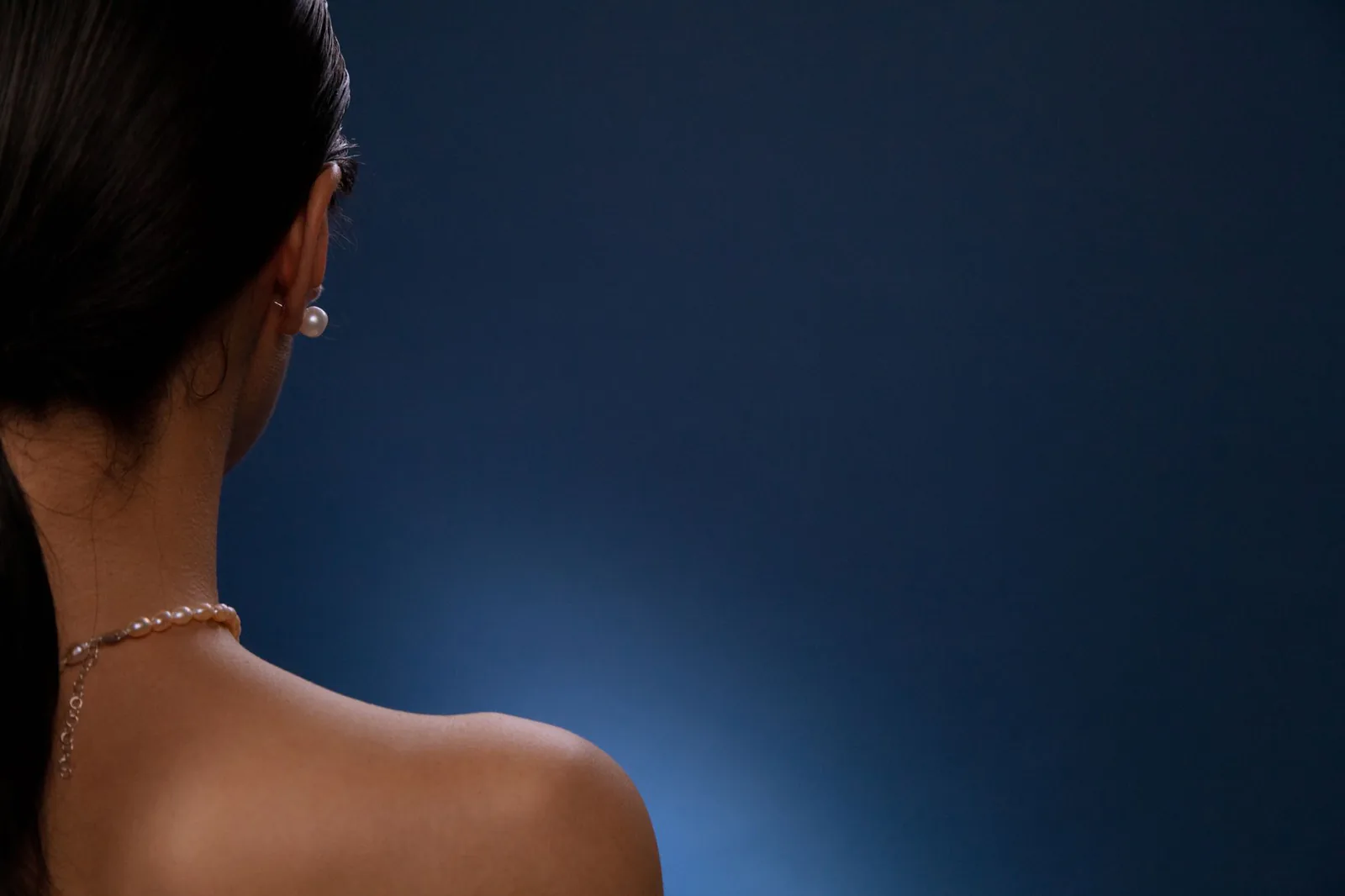 Pearl necklace worn on a bare shoulder