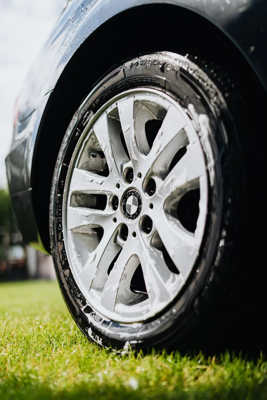 Close-up of a wheel being detailed with soap
