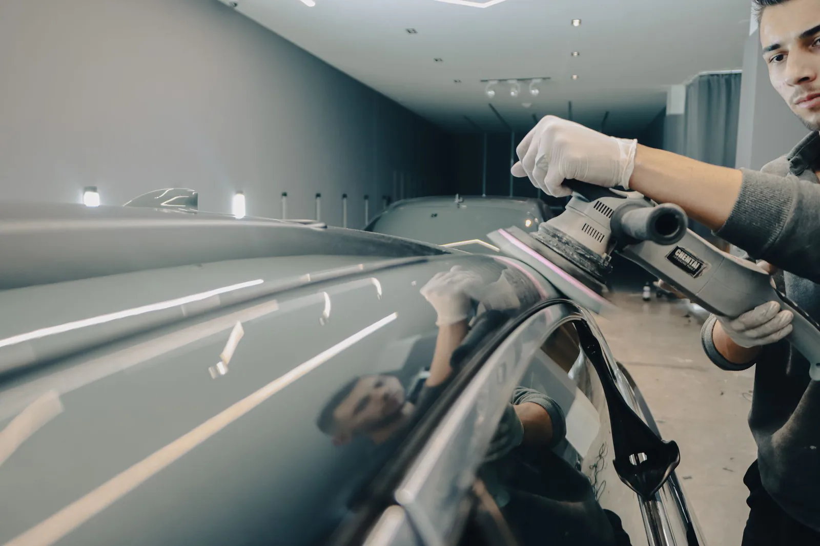 Detailer machine-polishing a vehicle roof for a flawless finish