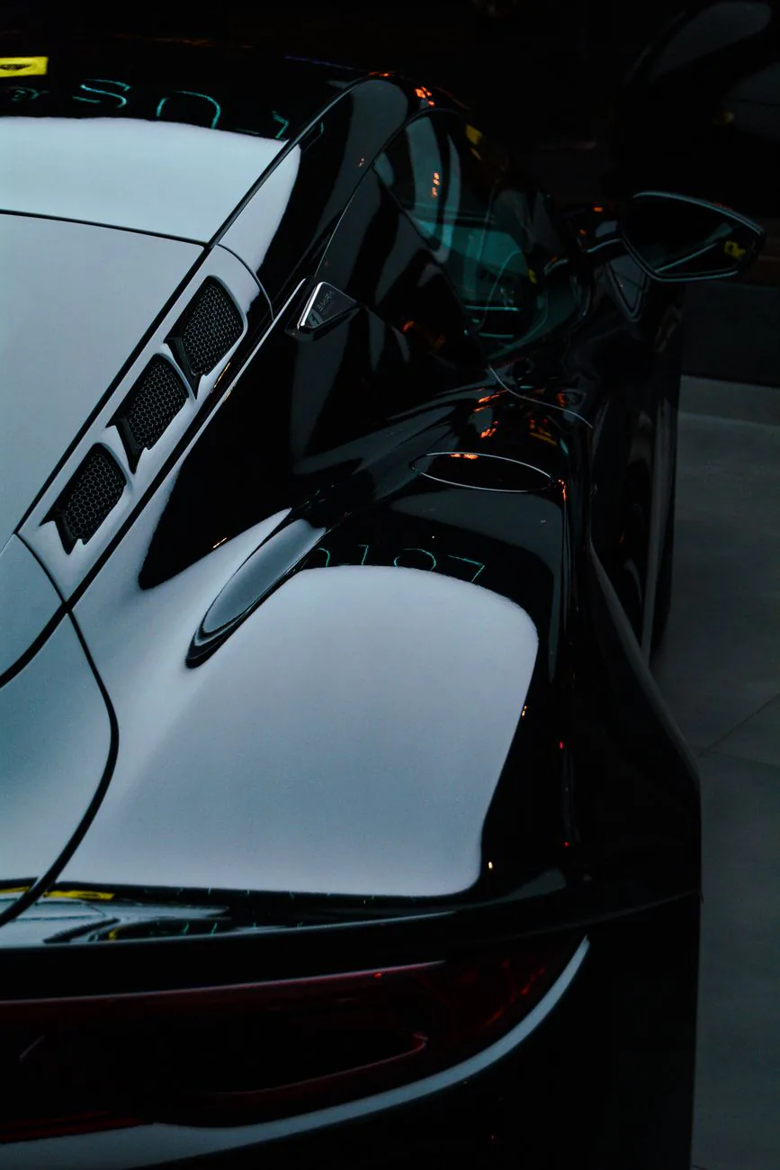 Glossy black sports car reflections after detailing