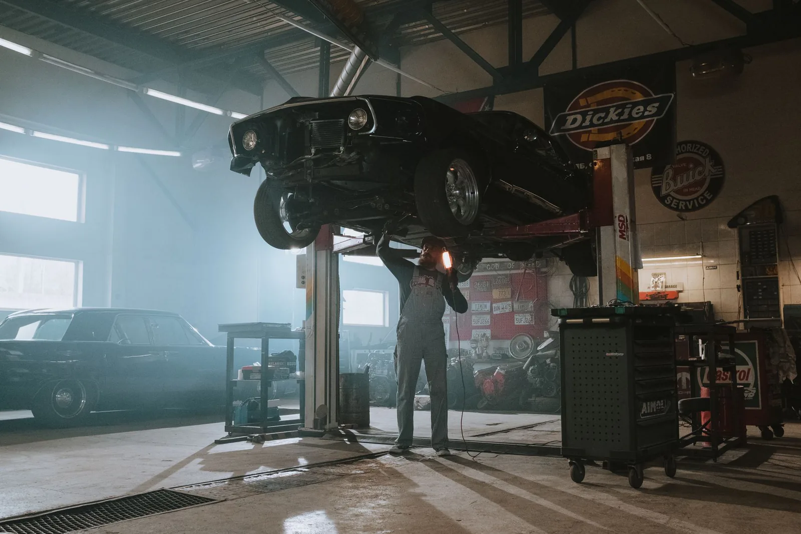 Technician inspecting a vehicle on a lift at SNL Automotive
