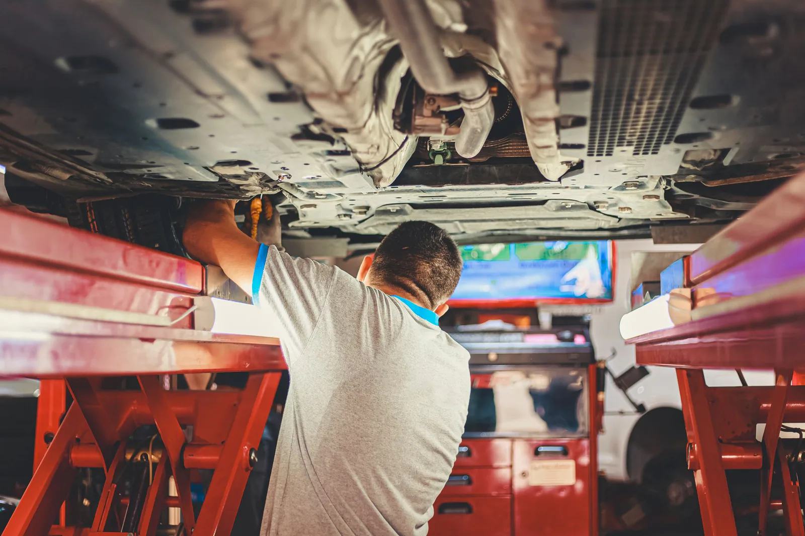 Mechanic working beneath a vehicle on a lift