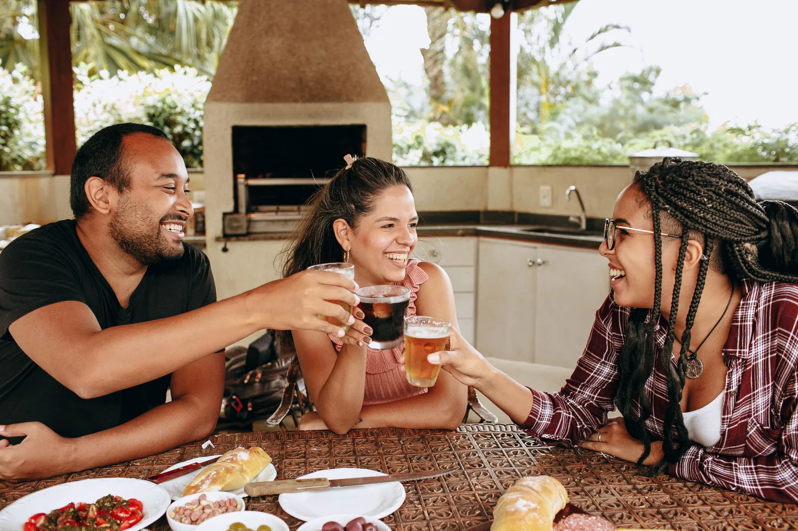 Friends laughing over an outdoor brunch table