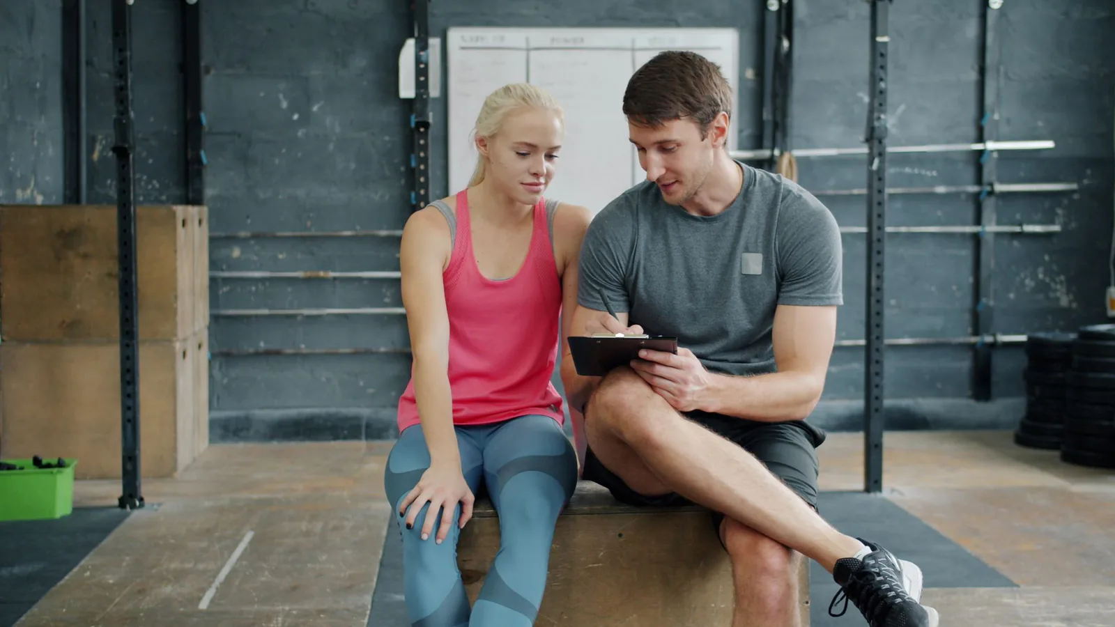 A personal trainer walking a client through a training plan in a gym