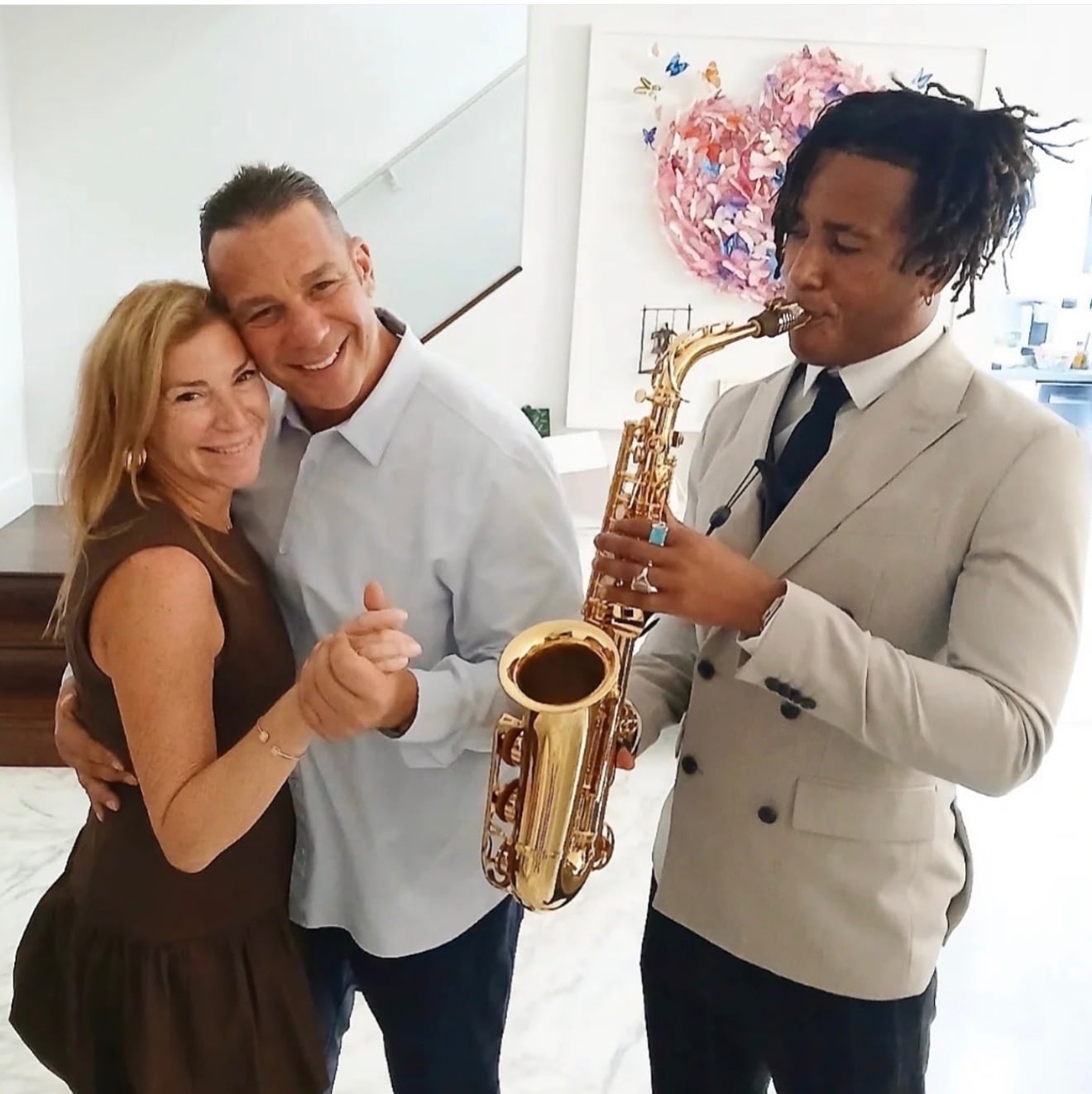 Couple dancing while a saxophonist performs at their event